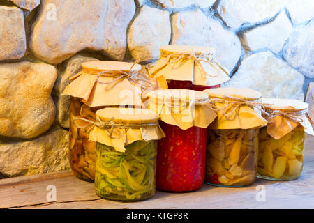 Download Home canned vegetables in glass jars near the stone wall. Pickled Stock Photo: 158320134 - Alamy