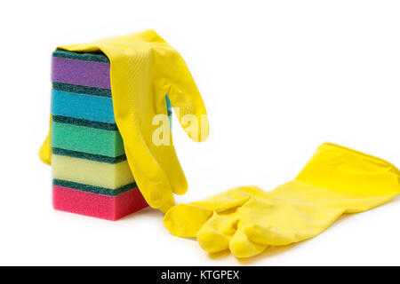 a stack of multicolored sponges and yellow rubber gloves for wet cleaning and dish washing on a white background with space for text Stock Photo