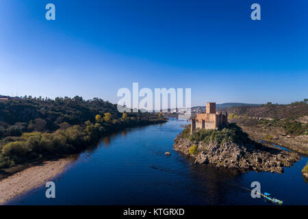 Aerial view of the Armourol Castle with a boat passing in the Tagus River in Portugal; Concept for travel in Portugal Stock Photo