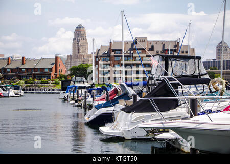 Exterior boats resting in Erie Basin Marina in foreground and apartments and Buffalo City Hall in background in Buffalo New York in Erie County Stock Photo