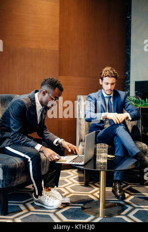 businessman using laptop to discuss information with colleague in modern office Stock Photo