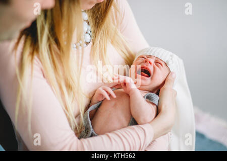 newborn cries in arms of his mother