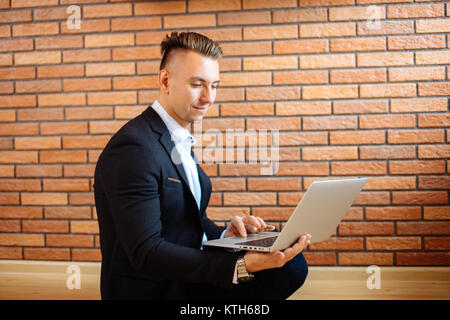 business man using laptop at home while sitting on floor Stock Photo