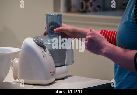 Close up of woman mixing dough in a Moulinex food processor for pastry on a kitchen counter Stock Photo