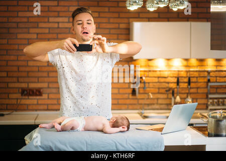 Father take photo on smartphone to Baby son Stock Photo