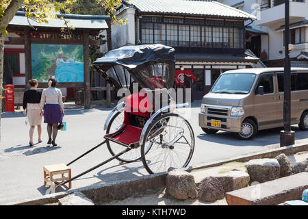 ITSUKUSHIMA, JAPAN-CIRCA APR, 2013: Rickshaw a two-wheeled passenger cart is on street of Miyajima. Pulled rickshaw is a popular form of transportatio Stock Photo