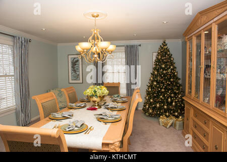 A formal dining room with table set, decorated for the Christmas holiday Stock Photo