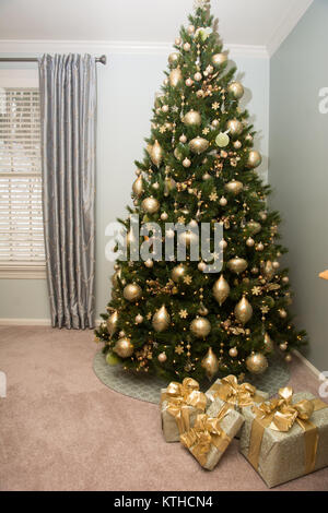 A beautifully decorated Christmas tree with gift package near it Stock Photo