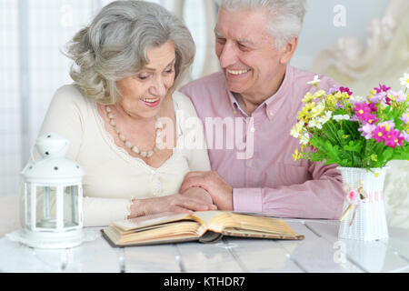 Portrait of happy senior couple reading magazine Stock Photo