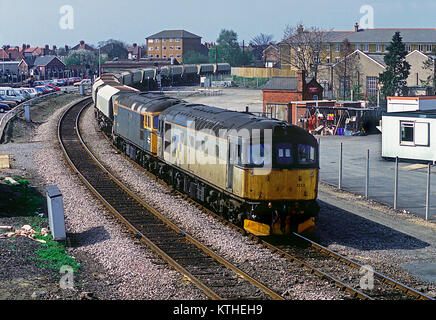 A pair of class 33 diesel locomotives numbers 33033 and 33023 working a train of MARCON wagons coming off the Greenford branch at West Ealing. 10th April 1991.