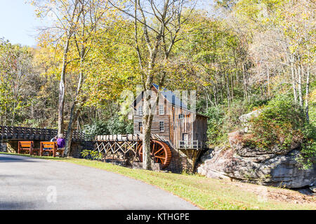 Clifftop, USA - October 19, 2017: Senior couple sitting on a bench in Babcock State Park looking at Old Grist Mill in West Virginia autumn Stock Photo