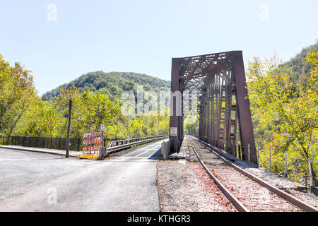 Metal steel covered small railroad bridge in Thurmond, West Virginia with weight limit sign and construction, nobody during autumn fall, highway road Stock Photo