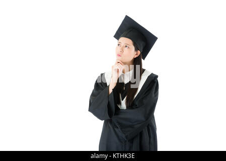 pretty attractive female student wearing graduation clothing when she finished college diploma studying class and standing on white background thinkin Stock Photo