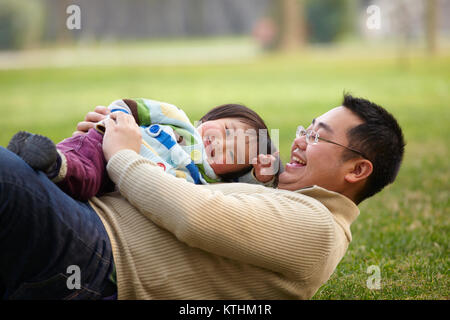 happy asian father playing with his little girl outdoor in the park Stock Photo