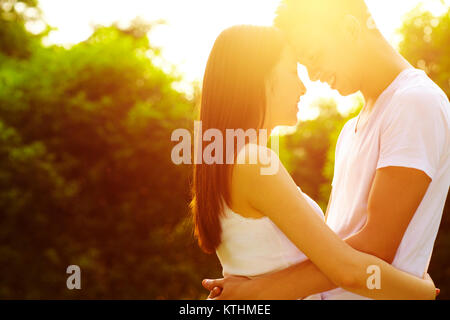 Young Chinese lover holding together in the park with beautiful summer afternoon light Stock Photo