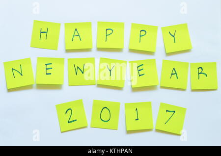yellow paper note writing happy new year 2017 stick on white background Stock Photo