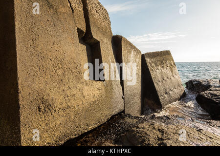 Breakwater blocks in the port of Puerto Rico, Gran Canaria, with the Atlantic Ocean in the background Stock Photo