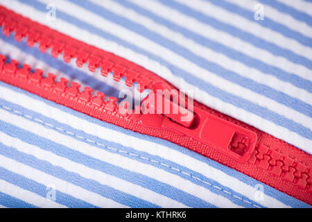 Red Zipper on White and Blue Striped Garment Stock Photo
