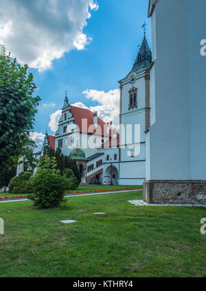 Green lawn outside a Catholic monastery in a small town in Poland. Beautiful and cosy place under blue sky with white clouds. Stock Photo