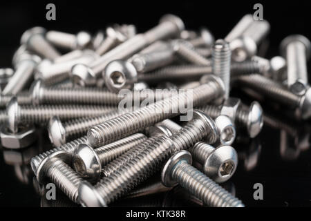 metal fasteners screws and nuts on black background. screw isolated on the black backgrounds. Nuts with bolts closeup Stock Photo