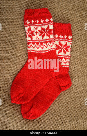 a pair of traditional red Christmas sock on a burlap background Stock Photo