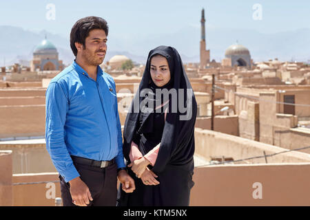 Yazd, Iran - April 21, 2017: Young Muslim couple in the background of the historic part of the city, clay buildings of the old town. Stock Photo