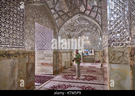 Yazd, Iran - April 22, 2017: A tourist with a camera examines the interiors of a mirrored mosque. Stock Photo