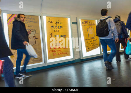 Paris, France, Anti French Advertising Protest Art, Metro Subway Ad Posters on wall, in Hallway of Invalides Station, activist billboards people, urban art Stock Photo