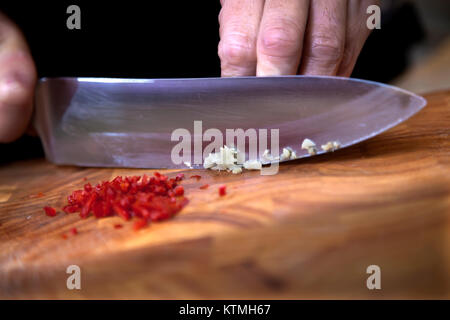 Food preparation - dicing garlic on chopping board Stock Photo