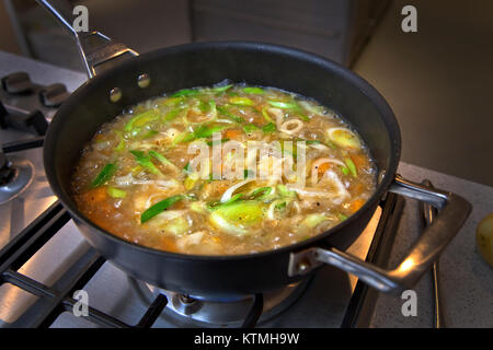 Vegetable soup simmering in pan on hob Stock Photo