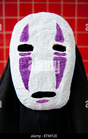 Close-up of the huge mask against the red background at the Comic Con, London, UK Stock Photo