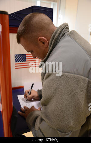 Staff Sgt. Kevin J. Hindes, a Troy, N.Y. resident and a member of the 42nd Infantry Division Headquarters and Headquarters Battalion, fills out an affidavit voting ballot at a polling station in Cortland, N.Y., N.Y. Soldiers currently supporting Hurricane Sandy recovery efforts voted at local polling stations after an executive order by Gov. Andrew Cuomo. The order allowed New Yorkers displaced by the storm to vote outside their home districts. (U.S. Army Photo by Spc. J.p. Lawrence, 42nd Infantry Division). Stock Photo