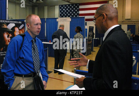 LATHAM, NY – Michael Winburn, a Time Warner Cable recruiter (right) speaks with Thomas Lang, a Gulf War and navy veteran (left) at the U.S. Chamber of Commerce’s “Hiring Our Heroes” job fair held at the New York National Guard armory here on Oct. 16. Over 200 veterans and service members took the opportunity to meet with about 70 potential employers and organizations, including Northwestern Mutual Financial Network, Federal Express and National Grid. The New York National Guard has also hosted “Hiring Our Heroes” events across New York state in places like Rochester, Syracuse, Buffalo, Farming Stock Photo