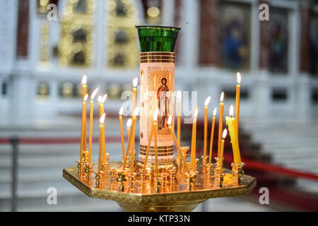 Close up candleholder with burning candles and image of Jesus Christ in Orthodox church Stock Photo