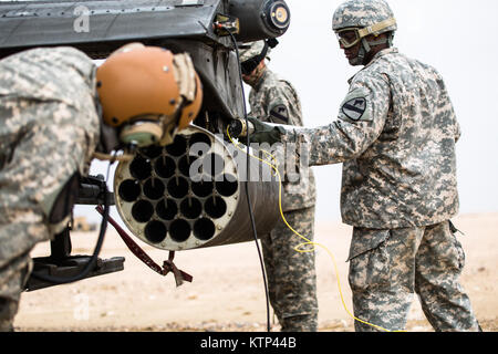 Soldiers from 4th Battalion, 227th Attack Reconnaissance Battalion, 1st Cavalry, now under the 42nd Combat Aviation Brigade, load an AH-64 Apache with 2.75 inch rockets during a Forward Arming and Refueling Point exercise with A Company, 642nd Aviation Support Battalion, 42nd CAB, on Jan. 15, 2014, near Camp Buehring, Kuwait.  The 42nd CAB, New York Army National Guard, is based in Kuwait and has assumed command of Army aviation assets in the region as part of Operation Enduring Freedom. (N.Y. Army National Guard photo by Spc. Harley Jelis/Released) Stock Photo