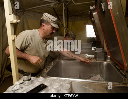 Staff Sgt. Robert Grimaldi and Pfc. Brandon Taylor, both cooks with the 642nd Aviation Support Battalion, 42nd Combat Aviation Brigade (CAB), prepare breakfast for CAB soldiers out of a field kitchen provided by the Royal Saudi Land Forces during Iron Hawk 14, at 5 A.M. on April 15th, 2014, near Tabuk, Saudi Arabia.  The cooks provided hot meals for 42nd CAB soldiers over the course of Iron Hawk and Friendship 14, a joint exercise between U.S. Army forces from the 42nd CAB, New York Army National Guard, and 2nd Brigade Combat Team, 4th Infantry Division, and Saudi Arabian ground and aviation f Stock Photo