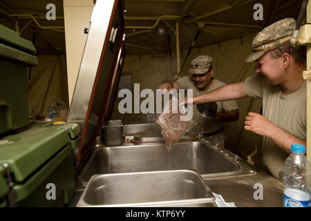 Staff Sgt. Robert Grimaldi and Pfc. Brandon Taylor, both cooks with the 642nd Aviation Support Battalion, 42nd Combat Aviation Brigade (CAB), prepare breakfast for CAB soldiers out of a field kitchen provided by the Royal Saudi Land Forces during Iron Hawk 14, at 5 A.M. on April 15th, 2014, near Tabuk, Saudi Arabia.  The cooks provided hot meals for 42nd CAB soldiers over the course of Iron Hawk and Friendship 14, a joint exercise between U.S. Army forces from the 42nd CAB, New York Army National Guard, and 2nd Brigade Combat Team, 4th Infantry Division, and Saudi Arabian ground and aviation f Stock Photo