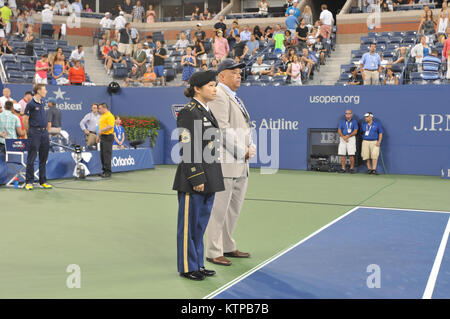 Flushing, NY – Sgt. 1st Class Sharon Rimal and Commissioner Terrance Holliday, New York City Mayor’s Office of Veterans Affairs, stand courtside at Arthur Ashe Stadium at the US Open Tennis Center in Flushing, N.Y. on Monday, Sept. 1, 2014.  Rimal, the Readiness NCO for the 27th Financial Management Co., NY Army National Guard, and Holliday, a retired U.S. Air Force Colonel, were recognized during the US Open Tennis Tournament’s third annual Military Appreciation Day.  (US Army Photo by Master Sgt. Dean Welch/Released) Stock Photo