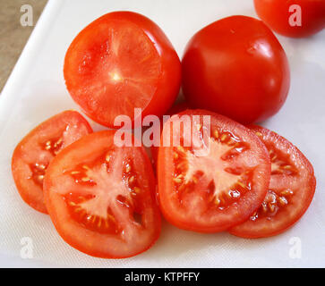 Freshly sliced Organic tomatoes on cutting board Stock Photo