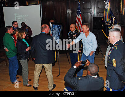 Phil Taylor, founder of The American Fallen Soldiers Project presents a photograph of Sgt. Mark Palmateer, a member of C Company, 1st Battalion 69th Infantry, who was Killed in Action in Logar Province, Afghanistan on June 26, 2008 while serving with the New York Army National Guard's 2nd Battalion 101st Cavalry , to Palmateer's family during an event at the Lexington Avenue Armory in New York City on Sunday, March 15. Taylor paints portraits of American service members who die in the line of duty and present them to families. The event took place during events leading up to the annual St. Pat Stock Photo