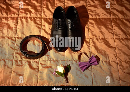 Close up image of shoes and bow tie of groom om beige background Stock Photo