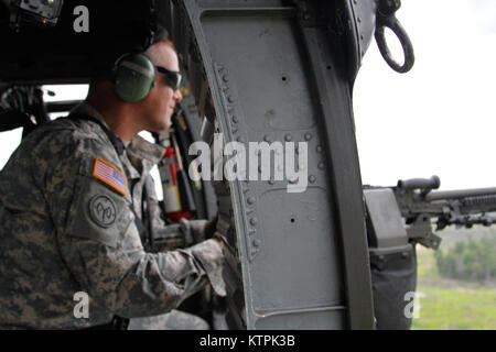 During a visit to Fort Drum Friday, July 17, 2015, 42nd Infantry Division commander Maj. Gen. Harry Miller and division assistant commander for support Brig. Gen. Gary Yaple met with Soldiers at the gunnery range and took their turns aboard a UH-60 Black Hawk helicopter for qualifying iterations. (U.S. Army photo by Capt. Jean Kratzer) Stock Photo