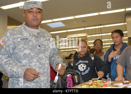 Student chefs (right) wait in anticipation as New York Army National Guard culinary specialist Sgt. Duwann Gordon (left) judges a meal they prepared using MRE food components at a Boards of Cooperative Educational Services (BOCES) vocational education facility in Goshen, N.Y. on Dec. 4, 2015. The students prepared meals with MREs as part of a New York Army National Guard educational challenge designed to test their skills and familiarize them with Army careers. The students chefs are, from left: Tyra Chase, a Middletown High School junior; Tushana Clarke and Nina Lucas, both juniors at Port Je Stock Photo