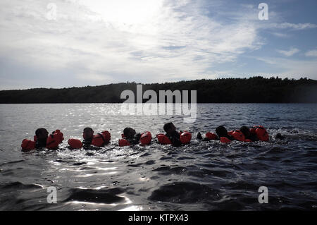 HOMESTEAD, FL - Members of the 101st Rescue Squadron conduct Water Survival Training (WST) near Homestead Air reserve Base on January 20, 2016. During this training, members train on the use of seven and twenty man survival rafts, the ability to work as a team in open water, and the use of their survival equipment. Additionally, aircrew members must conduct multiple dunks in the Shallow Water Egress Trainer in a four foot, man-made pool, and demonstrate an ability to exit an aircraft while upside down and completely submerged under water.   After conducting combat survival training in the subt Stock Photo