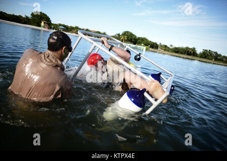 HOMESTEAD, FL - Members of the 101st Rescue Squadron conduct Water Survival Training (WST) near Homestead Air reserve Base on January 20, 2016. Aircrew members must conduct multiple dunks in the Shallow Water Egress Trainer in a four foot, man-made pool, and demonstrate an ability to exit an aircraft while upside down and completely submerged under water.   After conducting combat survival training in the subtropical Florida Everglades, aircrew must continue on to WST before completing their currency training.   (US Air National Guard / Staff Sgt. Christopher S Muncy / released) Stock Photo