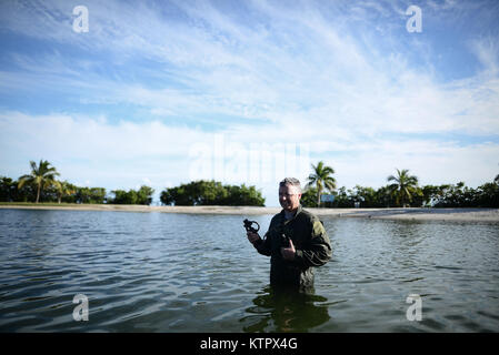 HOMESTEAD, FL - Members of the 101st Rescue Squadron conduct Water Survival Training (WST) near Homestead Air reserve Base on January 20, 2016. Aircrew members must conduct multiple dunks in the Shallow Water Egress Trainer in a four foot, man-made pool, and demonstrate an ability to exit an aircraft while upside down and completely submerged under water.   After conducting combat survival training in the subtropical Florida Everglades, aircrew must continue on to WST before completing their currency training.   (US Air National Guard / Staff Sgt. Christopher S Muncy / released) Stock Photo