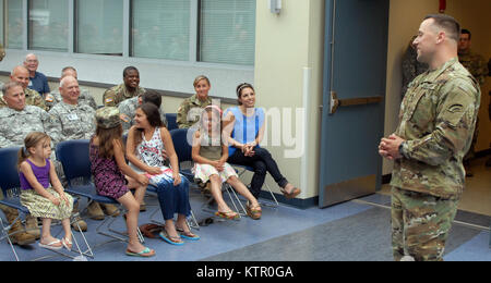 LATHAM, N.Y. -- New York Army National Guard Soldier Daniel Brunner’s family and military guests share smiles and laughs as Brunner (right) speaks following his promotion to the rank of sergeant major at the New York State Division of Military and Naval Affairs (DMNA) here on June 3. Brunner’s wife Erin is seated in the front row on the far right; His daughters are (from left to right): Sophia, Ava, Kayla and Madison. Over 100 Soldiers, Airmen and DMNA employees also attended the ceremony. An Iraq veteran, Brunner will assume new duties with Joint Force Headquarters. The Brunners live in Clift Stock Photo