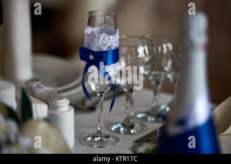 Close-up image of wine glass decorated with blue ribbon and lace for wedding ceremony Stock Photo