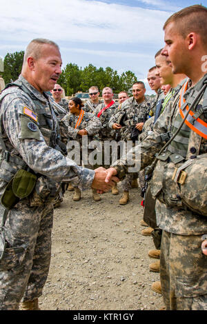 U.S. Army Reserve Col. Robert Benjamin, the commander of 655th Regional Support Command, presents a coin in recognition of outstanding ability to fix vehicle issues within 24 hours to  Spc. Tyler Harkins, all wheeled vehicle mechanic assigned to 220th Transportation Co., Keene, N.H., at the Army's Joint Readiness Training Center, Fort Polk, La., Saturday, July 16. The 220th Transportation Co. joined more than 5,000 Soldiers from other state Army National Guard units, active Army and Army Reserve troops as part of the 27th Infantry Brigade Combat Team task force, July 9-30, 2016. U.S. Army Nati Stock Photo