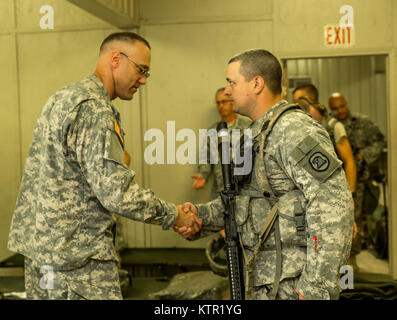 Lt. Col. Paul Groteluschen, commander of the 109th Medical Battalion, Iowa Army National Guard, presents a challenge coin to a Soldier of the 209th Area Support Medical Company for exemplary service during the unit's Joint Readiness Training Center (JRTC) rotation July 19, 2016, in Fort Polk, La.  The Iowa medical personnel joined more than 5,000 Soldiers from other state Army National Guard units, active Army and Army Reserve troops as part of the 27th Infantry Brigade Combat Team task force.  The Soldiers will hone their skills and practice integrating combat operations ranging from infantry Stock Photo